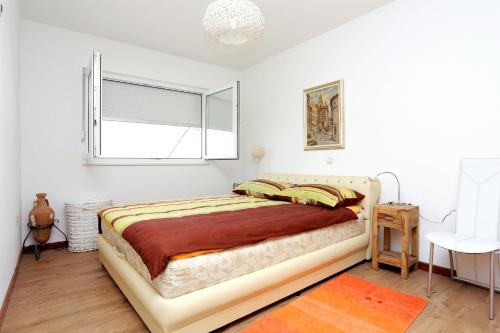 泰斯Seaside holiday house Stanici, Omis - 10357的一间卧室设有一张床和一个窗口