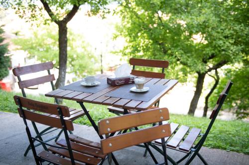 拉姆尼库沃尔恰全景酒店的一张木桌,上面有两把椅子和两个杯子