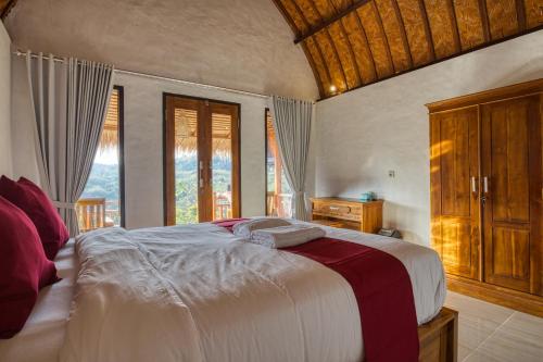 珀尼达岛Alit Cottage的一间卧室设有一张大床和一个窗户。