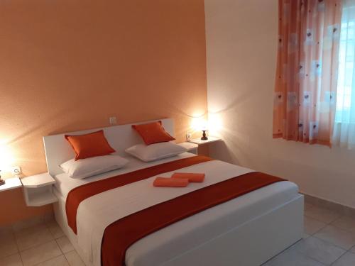 格拉达茨Apartments with a parking space Gradac, Makarska - 11332的一间卧室配有一张大床和两个橙色枕头