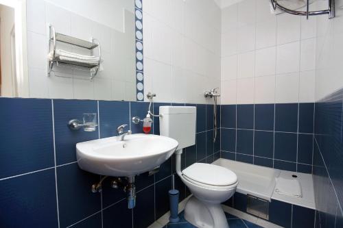 古维达里Apartment Pomena 10426b的蓝色和白色的浴室设有卫生间和水槽
