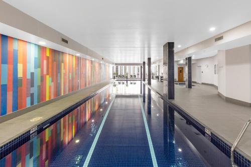 悉尼Meriton Suites Campbell Street, Sydney的一座游泳池,其墙壁色彩缤纷,位于一座建筑中