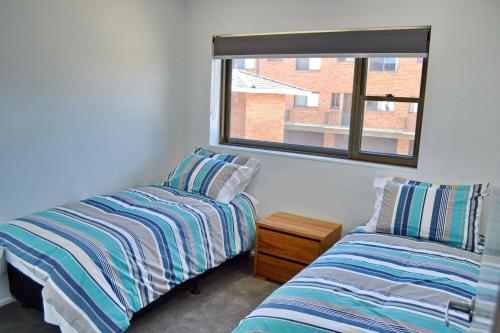 西南岩Waterford Apartment 5的一间卧室设有两张床和窗户。