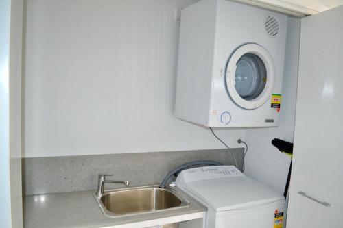 西南岩Waterford Apartment 5的一个带水槽和洗衣机的小厨房