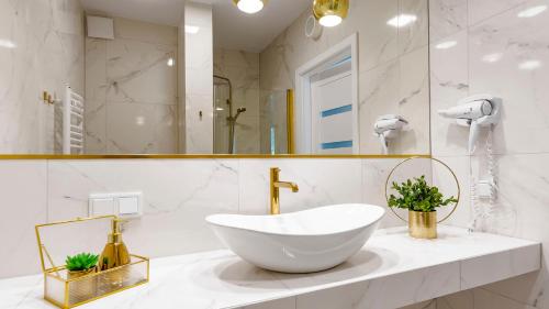 斯维诺乌伊希切VacationClub ApartPark Lividus Apartament 137的白色的浴室设有水槽和镜子