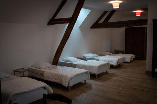 La Bussièregîte du château的一间带四张床的客房,位于带横梁的房间内