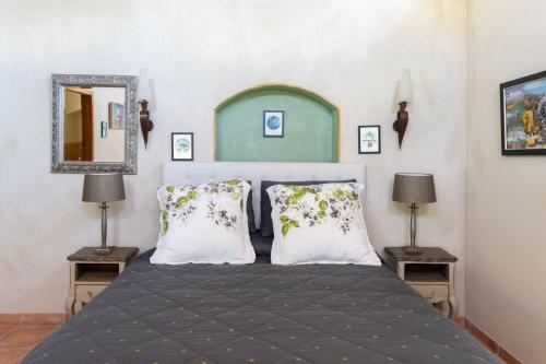 布伦海姆安特日亚精品旅舍的一间卧室配有一张带两盏灯和镜子的床