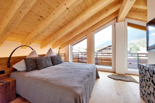 加尔米施-帕滕基兴Chalet Sunshine的一间卧室设有一张床和大窗户