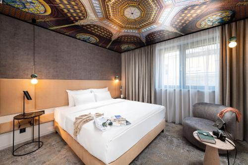 布达佩斯Three Corners Downtown Hotel的一间卧室设有一张大床和格子天花板