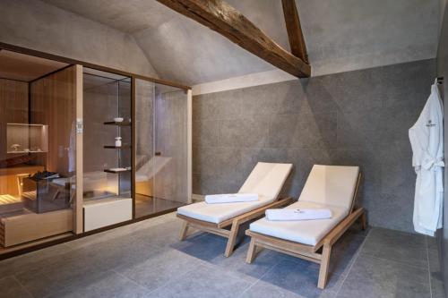 Vireux-WallerandChateau de Wallerand的带淋浴的客房内的2把白色椅子