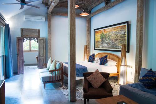 海神庙海神庙纳特雅酒店的一间卧室配有一张床、一把椅子和一张沙发