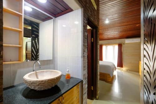 塔巴南Jero Delod Kedungu的一间带水槽的浴室和一张位于客房内的床