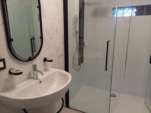 马尔梅迪Au lit de l'Amblève的浴室配有盥洗盆和带镜子的淋浴