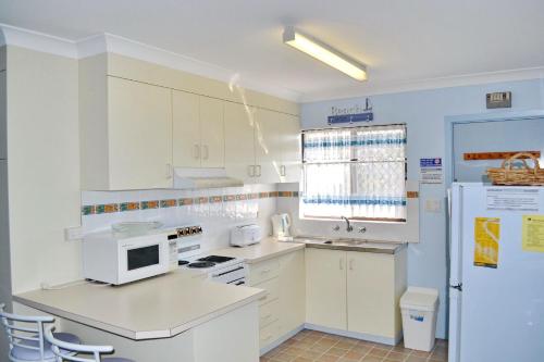 西南岩Village Centre 6的厨房配有白色橱柜和白色冰箱。