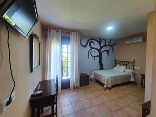 El GranadoPOSADA LOS PEDREGALES的一间卧室设有一张床、一台电视和一个窗口。