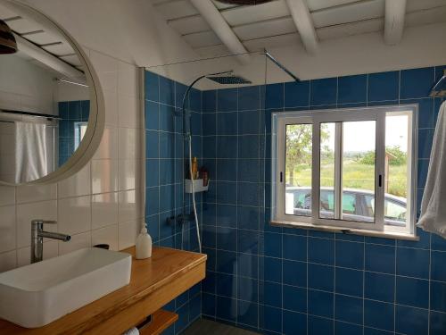 CampeirosCasa Azul do Cerro的蓝色瓷砖浴室设有水槽和窗户