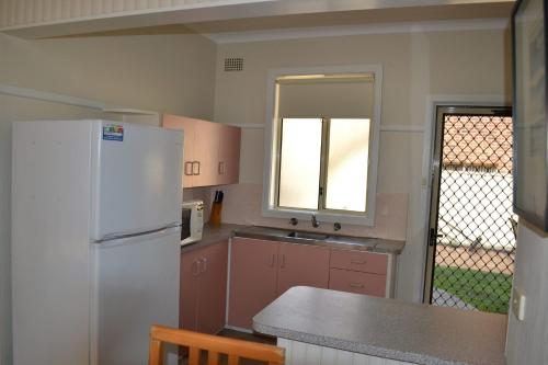 西南岩Clarkes Flat 1的厨房配有白色冰箱和水槽