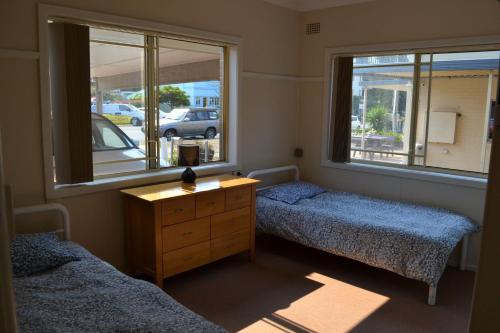 西南岩Clarkes Flat 1的一间卧室设有两张床、一个梳妆台和窗户。