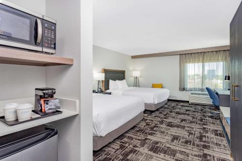 南本德La Quinta Inn & Suites by Wyndham South Bend near Notre Dame的一间酒店客房,设有两张床和电视