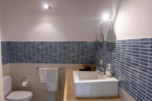 波托帕洛Casale Carratois - casa vacanze - Marzameni - Noto的蓝色瓷砖浴室设有水槽和卫生间