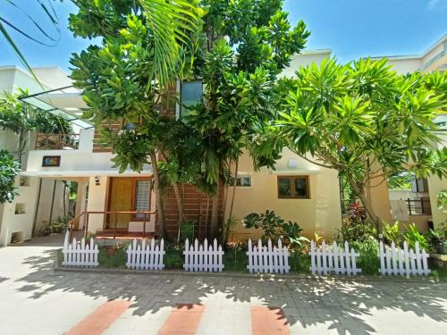 钦奈Coral Drive Villas -Your Private Beach Destination的前面有白色栅栏的房子