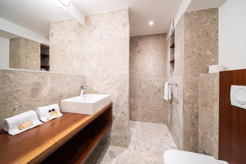 圣吉尔莱班热带公寓酒店的一间带水槽和镜子的浴室