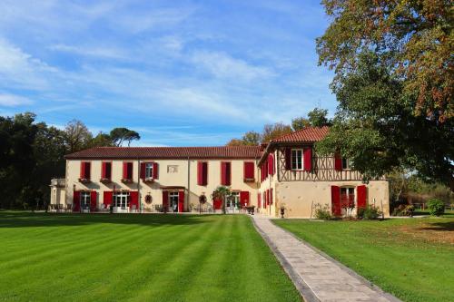 米朗德Maison D'hôtes Sainte-Marie的前面有绿色草坪的大房子