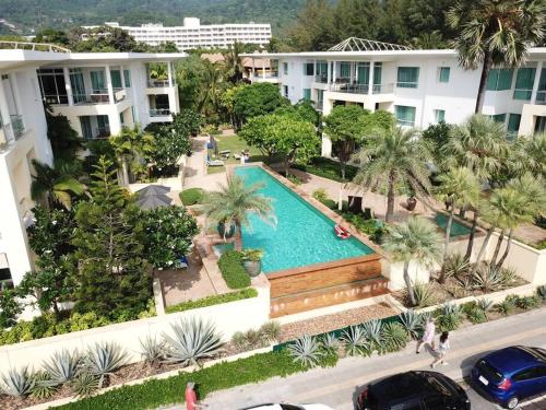 卡伦海滩Karon Sea View Beach Apartment的享有棕榈树和建筑的游泳池的顶部景致