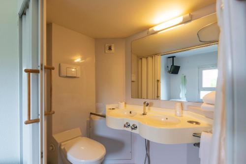 莫内托赛尔斯酒店的一间带水槽、卫生间和镜子的浴室
