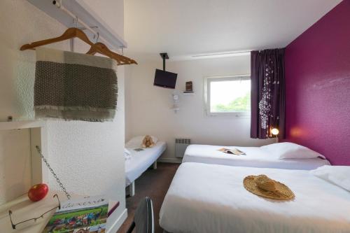 莫内托赛尔斯酒店的一间设有两张床和紫色墙壁的客房