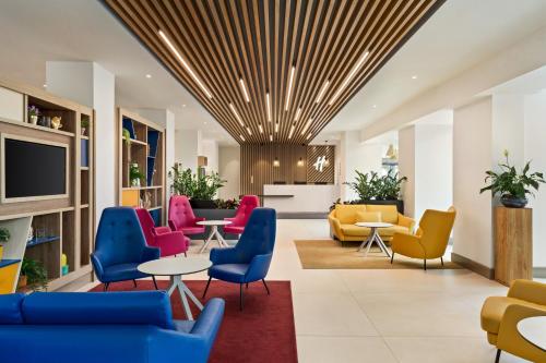 比肯希尔Holiday Inn Birmingham Airport - NEC, an IHG Hotel的大堂设有色彩缤纷的桌椅