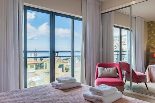 丰沙尔Urban Paradise by Madeira Sun Travel的一间卧室设有一张床和一个大窗户