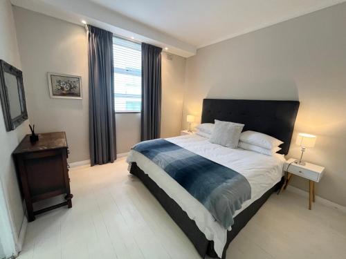 开普敦Seapoint Gem的一间卧室设有一张大床和一个窗户。