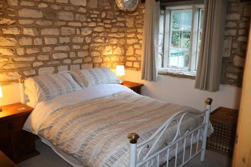 斯特劳德Flat 1 - The Old Mill - Bowbridge Lock - Stroud的一间卧室设有一张床和石墙