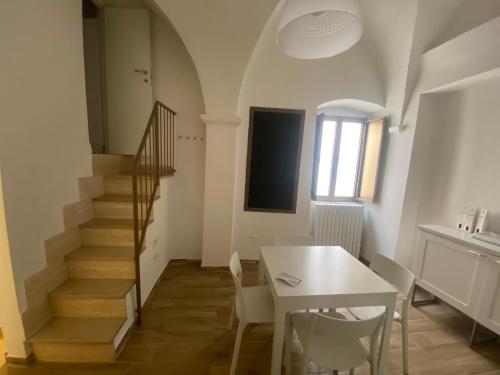 普蒂尼亚诺La Chianca的一间带桌子和楼梯的用餐室