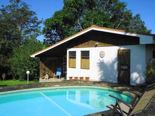La Garita费尔南多住宿加早餐旅馆的一座小房子,前面设有一个游泳池