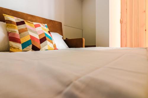 塞辛布拉Refúgio da Fortaleza的床上有两张色彩缤纷的枕头