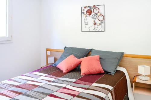 比亚里茨Appartement La Coline Bleue的一间卧室配有一张带两个粉红色枕头的床