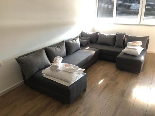 斯特鲁加Kubi Hotel的客厅配有灰色沙发和搁脚凳