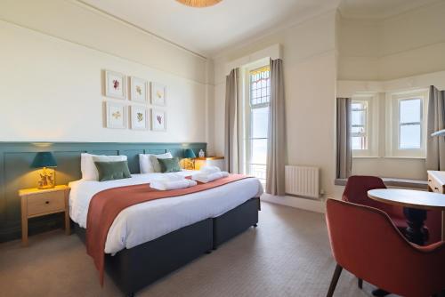 克罗默克里夫顿维尔酒店的一间卧室配有一张大床和一把椅子