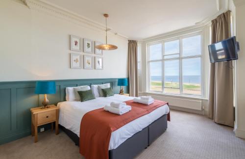 克罗默克里夫顿维尔酒店的一间卧室设有一张大床和一个窗户。