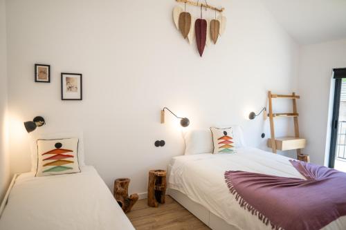 布拉干萨Montesinho Eco-Resort的白色墙壁客房的两张床