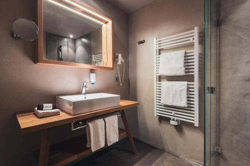 科瓦拉因巴迪亚阿里亚拉酒店的一间带水槽、镜子和淋浴的浴室