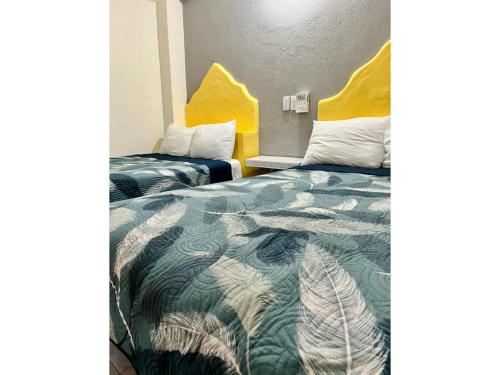 圣克鲁斯华特库Hotel Ocean Huatulco的酒店客房设有两张床和黄色床头板