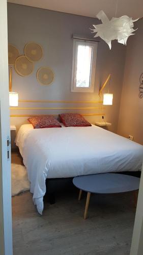 阿夫里耶Gîte T2 A l'orée d'Angers的卧室设有一张白色大床和一扇窗户。