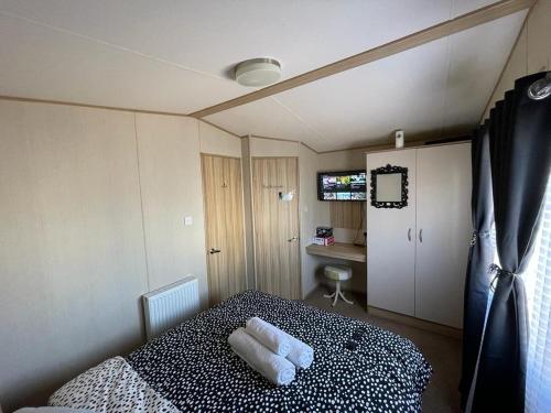 滨海莱斯当Holiday Park Caravan Fluffy in Harts Holiday Park的一间卧室配有一张床,上面有两条毛巾