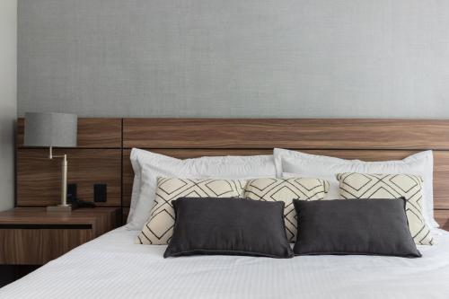 墨西哥城Capitalia - Apartments - Polanco - Julio Verne的卧室配有白色的床和木制床头板