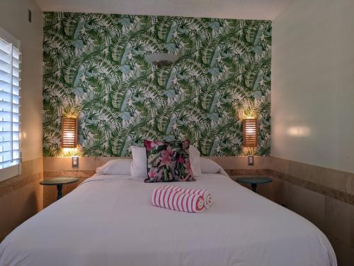 圣地亚哥兰乔汽车旅馆的一间卧室设有一张白色大床和绿色的墙壁