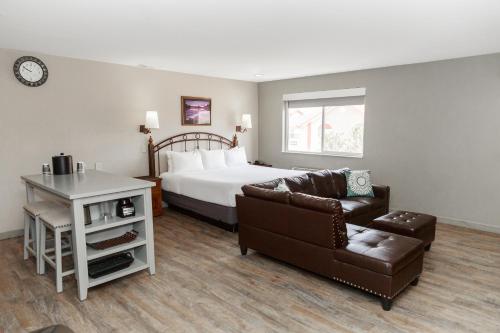 摩押拱道酒店的一间卧室配有一张床、一张沙发和一把椅子
