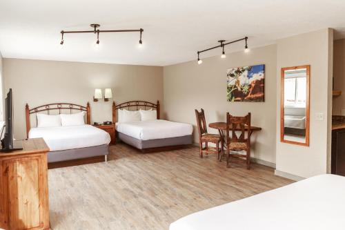 摩押拱道酒店的一间卧室配有两张床和一张桌子,还有一间用餐室